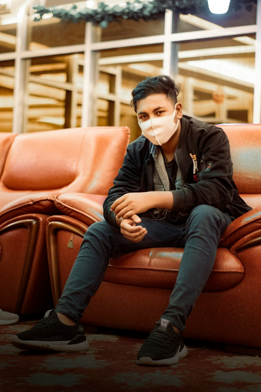 Young person reading news on a smartphone while sitting on a sofa